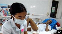 A nurse, wearing protective mask an gloves reads to a HIV/AIDS patient at the Phra Baht Nam Phu AIDS hospice near Lopburi, Thailand (File)