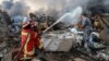 Firefighters spray water on a fire following an explosion in Beirut's port area, Lebanon, Aug. 4, 2020. 