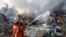 Firefighters spray water on a fire following an explosion in Beirut's port area, Lebanon, Aug. 4, 2020. 