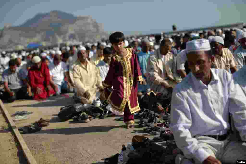 Seorang anak laki-laki berdiri di samping jemaah sholat Idul Fitri di Palermo, Italia, 8 Agustus 2013.