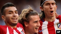 Antoine Griezmann, au centre, célèbre son but avec ses coéquipiers Filipe Luis, à droite, et Correa, à gauche, lors d'un match de football de la Liga espagnole entre le Real Madrid et l'Atlético de Madrid au stade Sant