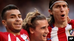 Antoine Griezmann, au centre, célèbre avec ses coéquipiers après avoir marqué lors d'un match entre le Real Madrid et l'Atlético de Madrid.