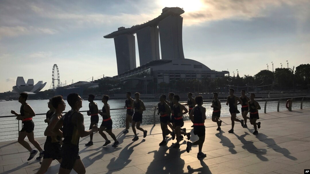 FILE - Runners pass in front of the Marina Bay Sands resort, one of several possible venues for the upcoming Trump-Kim summit, in Singapore.