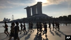 FILE - Runners pass in front of the Marina Bay Sands resort, one of several possible venues for the upcoming Trump-Kim summit, in Singapore.