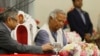 FILE - Muhammad Yunus signs a document after taking the oath of office as the head of Bangladesh's interim government, in Dhaka, Bangladesh, Aug. 8, 2024.