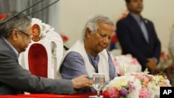 FILE - Muhammad Yunus signs a document after taking the oath of office as the head of Bangladesh's interim government, in Dhaka, Bangladesh, Aug. 8, 2024.