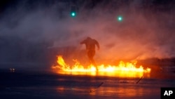 ARCHIVO - Un manifestante huye de los cañones de agua de la policía durante los enfrentamientos después de una marcha por el aniversario del asesinato del activista indígena mapuche Matías Catrileo en Santiago, Chile. [Foto AP]