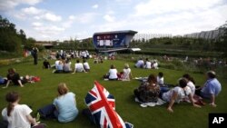 Spectators watch a live broadcast of an event at the Olympic Park during the 2012 Olympics in London, July 28, 2012.