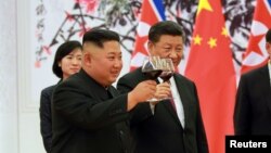 Ông Kim Jong Un và ông Tập Cận Bình chúc mừng nhau ở Bắc Kinh, Trung Quốc, ngày 20/6/2018.