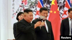 Kim Jong Un et Xi Jinping, Pékin, Chine, le 20 juin 2018. 