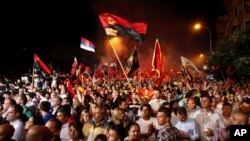 FILE - Supporters of the ruling conservative VMRO-DPMNE party rally in front of the Parliament building in Skopje, Macedonia, May 18, 2015. 