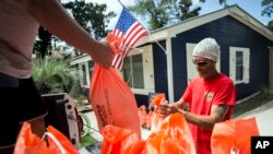 Tom Sikes, right, helps his friend Joey Spalding, left, fill sandbags at Spalding's home in Tybee Island, Ga., Sept. 3, 2019, before the potential arrival of Hurricane Dorian. Spalding's home was flooded by 3 feet of water during Hurricane Irma in 2017.