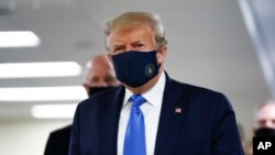 Presiden AS Donald Trump mengenakan masker saat mengunjungi Walter Reed National Military Medical Center di Bethesda, Maryland (11/7). 