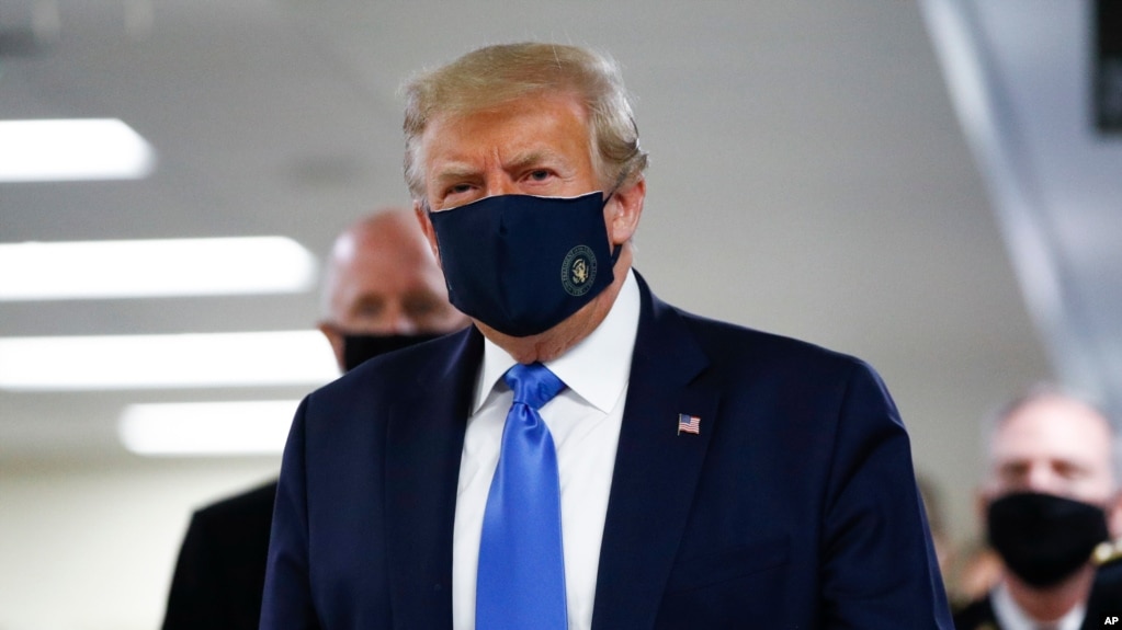President Donald Trump wears a mask as he walks down the hallway during his visit to Walter Reed National Military Medical Center in Bethesda, Md., Saturday, July 11, 2020. (AP Photo/Patrick Semansky)
