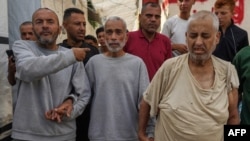 Palestinian men who had been detained by Israeli forces arrive after their release for a check-up at the Al-Aqsa Martyrs Hospital in Deir al-Balah in the central Gaza Strip on July 1, 2024.
