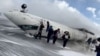 Passengers leave a Delta Air Lines CRJ-900 jet after it crashed on landing at Toronto Pearson International Airport in Mississauga, Ontario, Canada, Feb. 17, 2025 in a still image from video. 