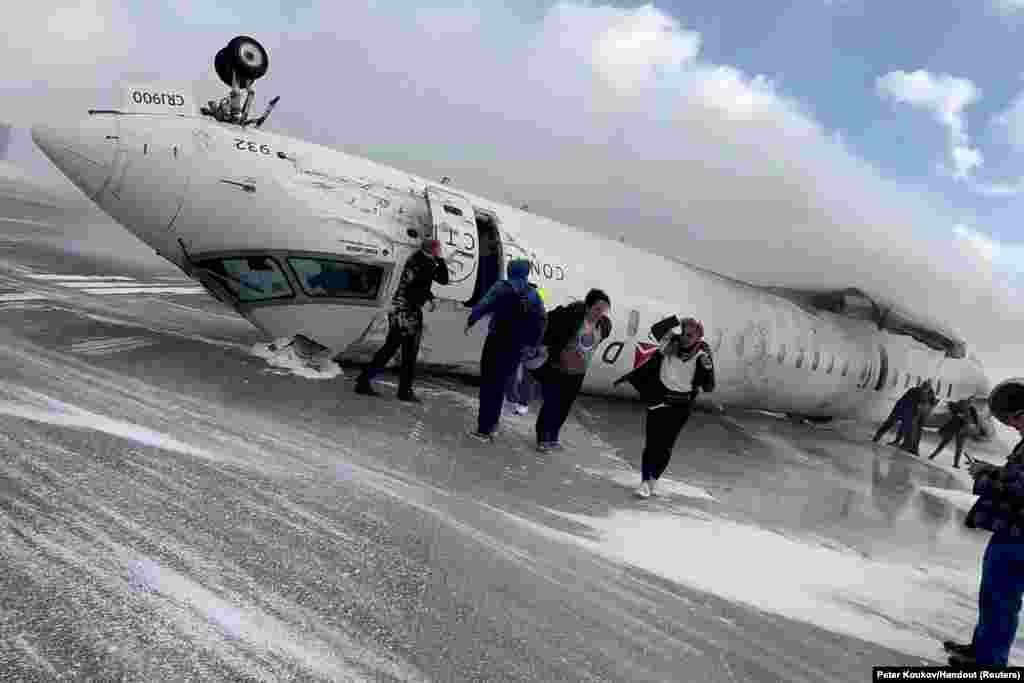 Passengers leave a Delta Air Lines CRJ-900 jet after it crashed on landing at Toronto Pearson International Airport in Mississauga, Ontario, Canada, Feb. 17, 2025 in a still image from video. 