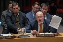 FILE - Russian Ambassador to the United Nations Vassily Nebenzia holds up a copy of a report as he speaks during a Security Council meeting at United Nations headquarters in New York, April 5, 2018.