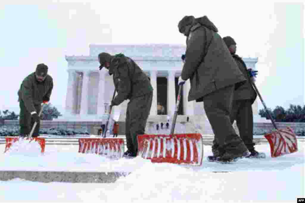 From left, Antwan Hunter, Corey Felder, Shawn Mallory, and George Mickle, all with the National Park Service, shovel snow from the steps of the Lincoln Memorial in Washington, Thursday, Dec. 16, 2010. (AP Photo/Jacquelyn Martin)