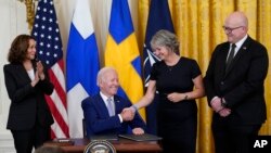 Serokê Amerîka Joe Biden li Qesra Sipî belgeyên êrêkirina endambûna Fînlandîya û Swêdê yên NATO’yê îmza dike, 9 Tebax, 2022.