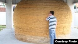 A tourist looks at the World's Largest Ball of Twine. (Credit: RoadsideAmerica.com) 