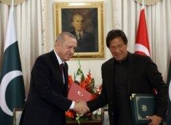Turkey's President Recep Tayyip Erdogan, left, and Pakistan Prime Minister Imran Khan shake hands after signing of several agreements, in Islamabad, Pakistan, Feb. 14, 2020.