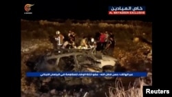 Footage from Al-Mayadeen Tv shows emergency teams working next to a burnt vehicle at the scene where Hezbollah says an Israeli strike killed three children, in southern Lebanon, Nov. 5, 2023. 