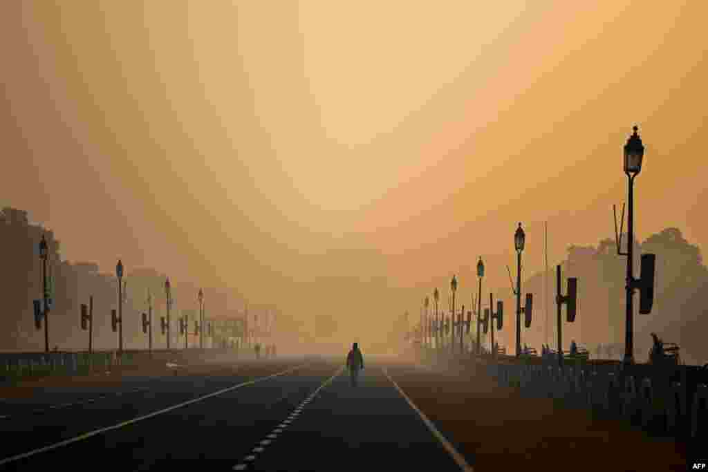 A man walks along Rajpath, a ceremonial boulevard, amid smoggy conditions in New Delhi, India.