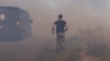 A Ukrainian serviceman runs to help farmers extinguish a burning field near Pokrovsk, Donetsk region, on Sept. 16, 2024, amid the Russian invasion of Ukraine.