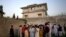 FILE - local residents gather outside a house in Abbottabad, Pakistan, where al-Qaida leader Osama bin Laden was killed in a raid the day before.