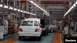 FILE - Cars are seen inside the Saipa Syria Factory in the industrial city of Hassia in Homs, Syria, Sept. 9, 2018.