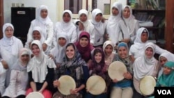 Lima mahasiswi asal Amerika (duduk di barisan depan) berfoto bersama ibu-ibu jamaah masjid di Plosokuning, Yogyakarta. Para mahasiswi AS ikut menyanyikan irama Hadrah dengan memainkan alat musik terbang.