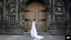 FILE - A Filipino bride arranges her gown before her wedding at a Catholic church in Manila, Philippines.