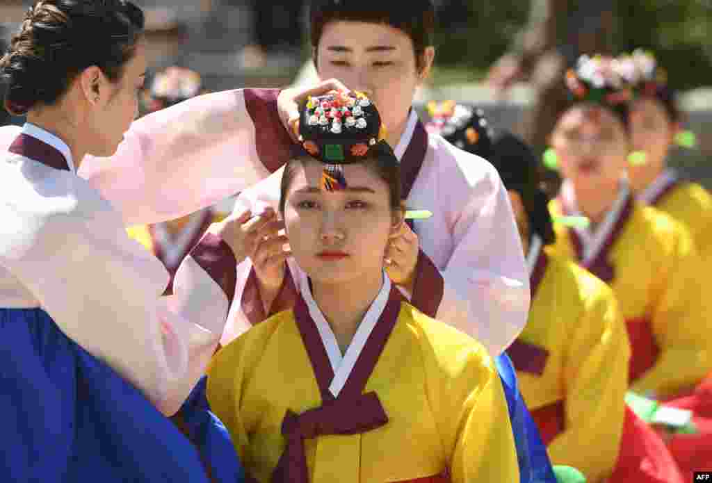 A young South Korean woman wears a traditional Korean flower cap during a traditional Coming-of-Age Day ceremony to mark adulthood at Namsan hanok village in Seoul.