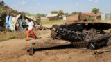 FILE - A man walks past the remains of a tank destroyed during fighting between government and rebel forces on July 10, 2016, in the Jebel area of the capital Juba, South Sudan, July 16, 2016.