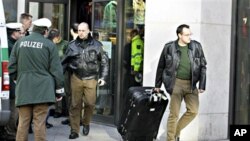 A police officer carries a suspected case out of a shop in Duisburg, western Germany, 19 Nov. 2010