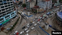 A line of vehicles drive through Shwegontai junction, one of the busiest junctions in the city, in Rangoon, July 3, 2013.