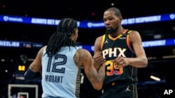 El base de los Memphis Grizzlies, Ja Morant (12), y el delantero de los Phoenix Suns, Kevin Durant (35), se dan la mano después de un partido de baloncesto de la NBA, el martes 11 de febrero de 2025, en Phoenix. AP/Rick Scuteri