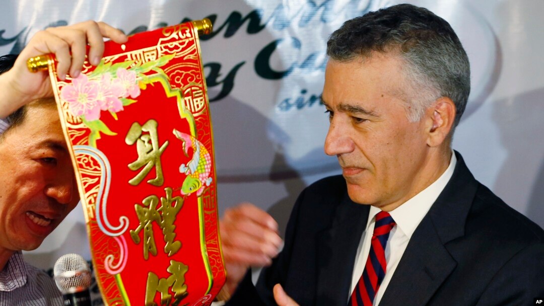 U.S. Ambassador to the Philippines Philip Goldberg, right, is presented a Chinese New Year scroll by journalist Wilson Flores during a forum Wednesday, Feb. 3, 2016 at suburban Quezon city, northeast of Manila, Philippines.