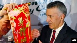 U.S. Ambassador to the Philippines Philip Goldberg, right, is presented a Chinese New Year scroll by journalist Wilson Flores during a forum Wednesday, Feb. 3, 2016 at suburban Quezon city, northeast of Manila, Philippines.