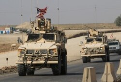 FILE - A convoy of U.S. military vehicles is seen at the Iraqi-Syrian border crossing, on the outskirts of Dohuk, Iraq, Oct. 21, 2019.