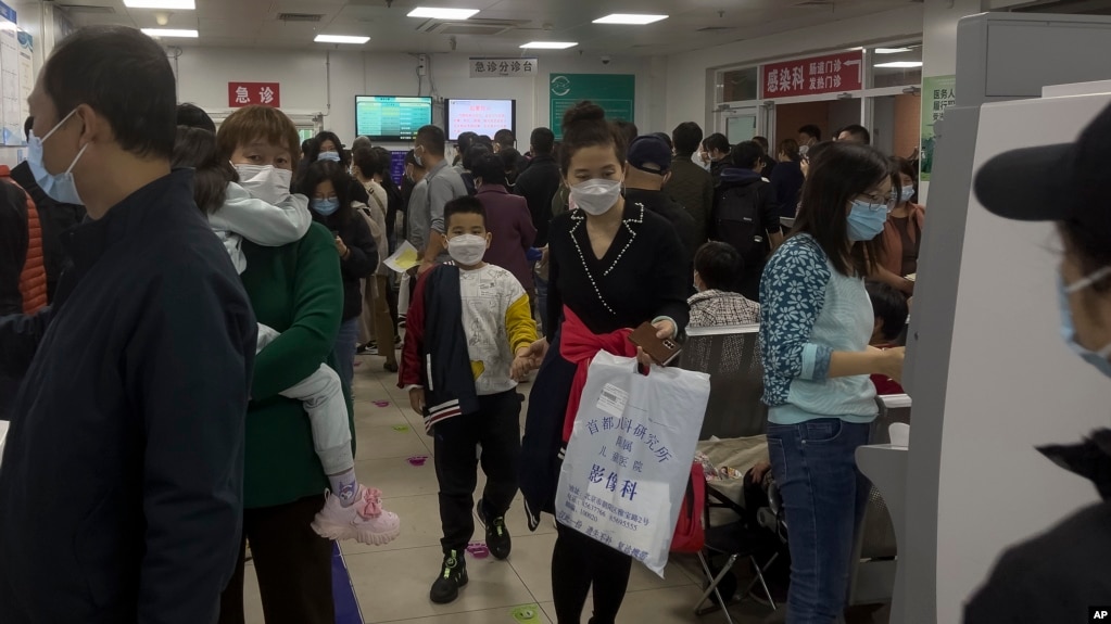 2023 年 10 月 30 日，北京一家儿童医院的家长带着孩子在拥挤的候诊室里等待。中国各地呼吸道疾病激增，引起了世界卫生组织的关注。