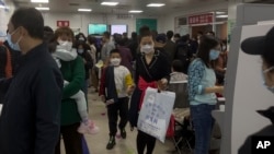 2023 年 10 月 30 日，北京一家兒童醫院的家長帶著孩子在擁擠的候診室等待。 中國各地呼吸道疾病激增，引起了世界衛生組織的關注。