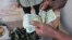 FILE - A vendor counts Syrian currency notes in Damascus, November 13, 2012. 