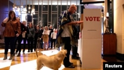 Eddie Craig Monarch reviews his ballot while his dog Sherlock waits at a polling place on Super Tuesday in Oklahoma City, Oklahoma, March 3, 2020. 