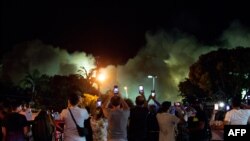 Orang-orang menyaksikan sisa menara Champlain South dihancurkan oleh ledakan terkendali di Surfside, Florida, utara Miami Beach, pada 4 Juli 2021. (Foto: AFP)