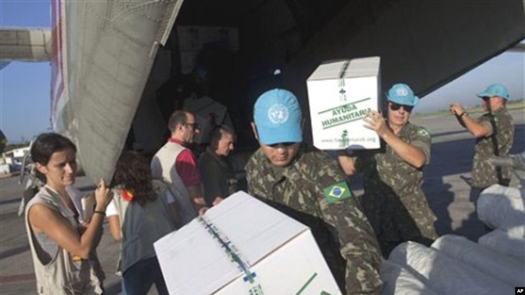 Laura Cartanya, left, representing the Spanish Agency for International Development Cooperation (AECI), supervises the unloading of humanitarian aid items for Haiti's fight against cholera at the international airport in Port-au-Prince, 27 Oct 2010