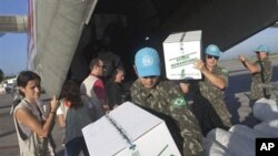 Laura Cartanya, left, representing the Spanish Agency for International Development Cooperation (AECI), supervises the unloading of humanitarian aid items for Haiti's fight against cholera at the international airport in Port-au-Prince, 27 Oct 2010