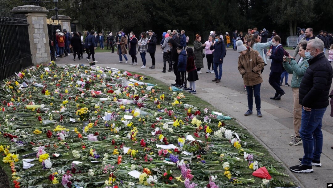 Warga meletakkan bunga di luar Kastil Windsor dekat London untuk mengenang Pangeran Philip, hari Minggu (11/4).
