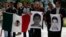 Manifestantes sostienen retratos de los estudiantes muertos en Iguala, México.